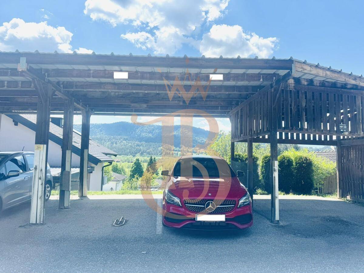Überdachter Carport bietet Schutz für Fahrzeuge mit Blick auf die umliegende Landschaft.