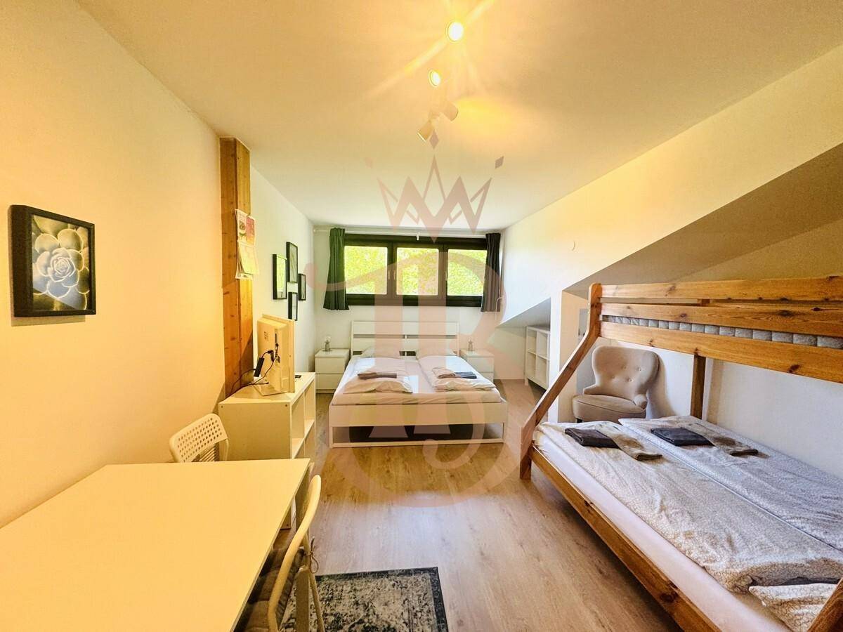 Geräumiges Schlafzimmer mit Doppelbett, Etagenbett und Essbereich, ideal für Familien.