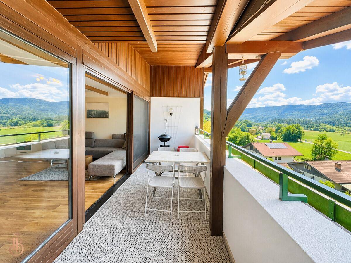 Geräumiger Balkon mit Esstisch und Stühlen, ideal für Mahlzeiten im Freien mit Bergblick.