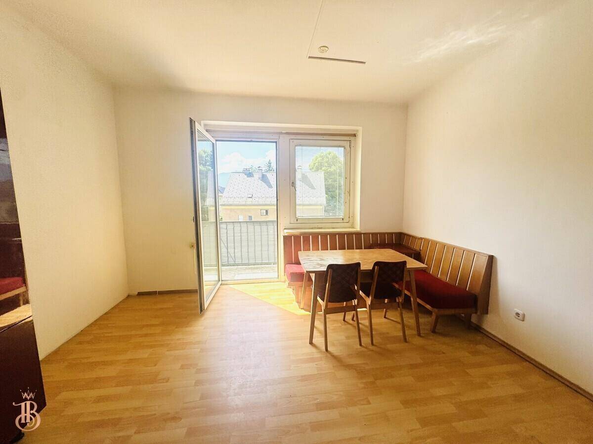 Gemütlicher Essbereich mit Eckbank, Holztisch und direktem Zugang zum sonnigen Balkon.