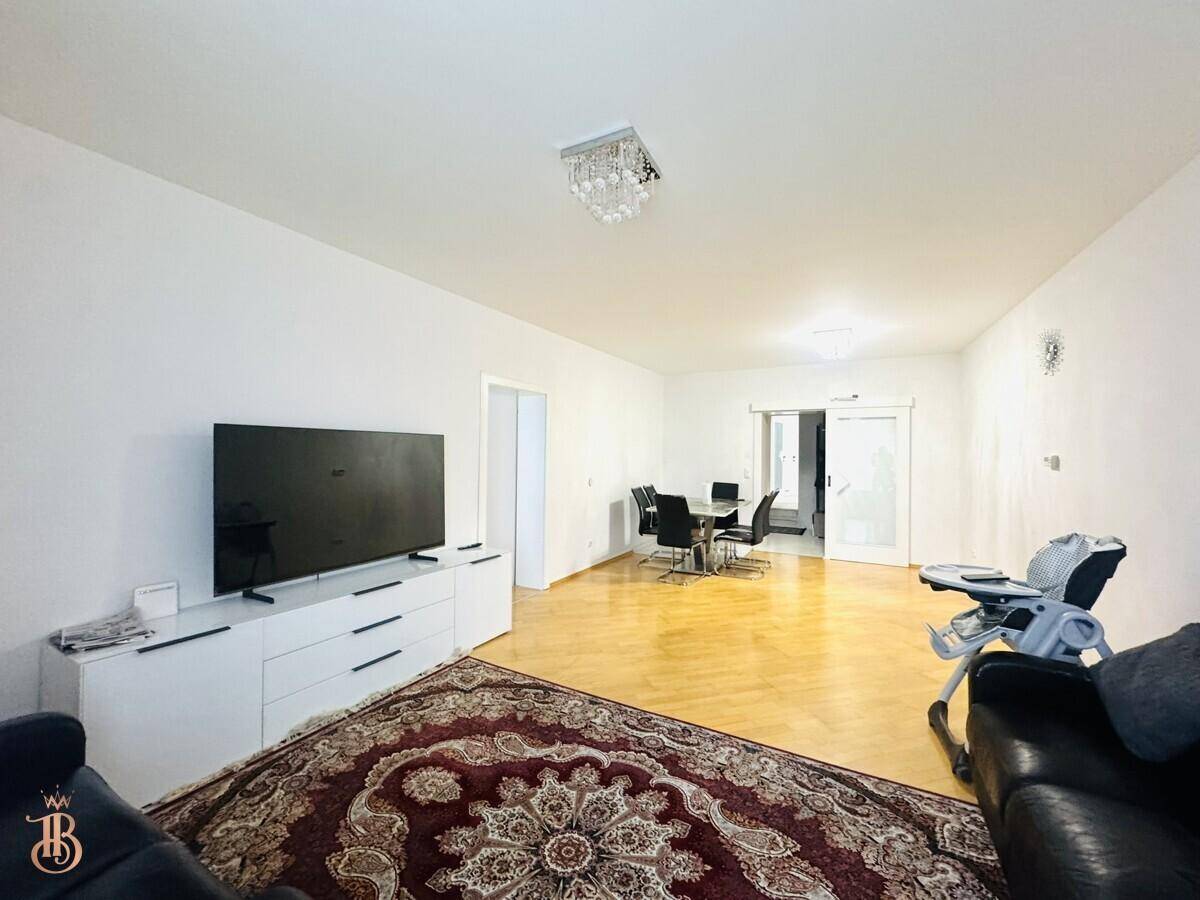 Geräumiger Wohn- und Essbereich mit Holzboden und modernem Kronleuchter.