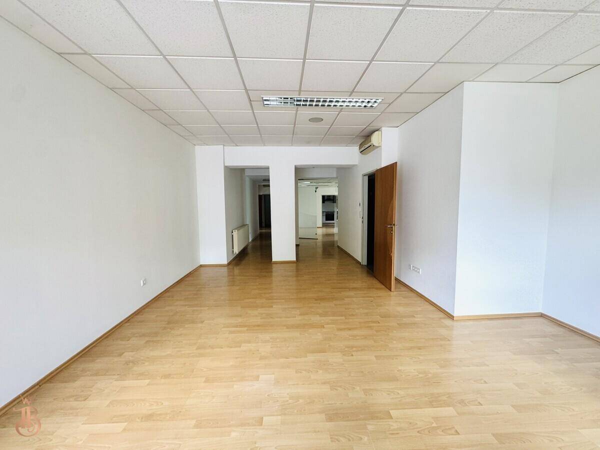Großer, leerer Raum mit Laminatboden und abgehängter Decke, vielseitig nutzbar.