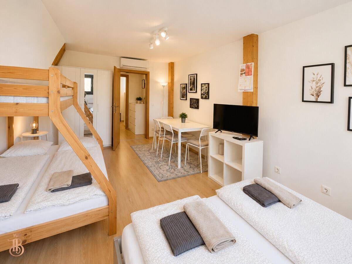 Familienfreundliches Schlafzimmer mit Etagenbett, Doppelbett und Essbereich für Komfort und Funktionalität.