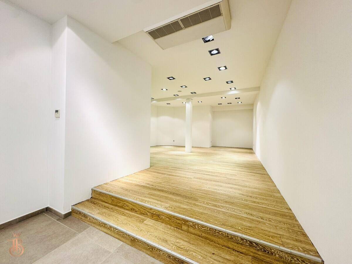 Übergangsbereich mit Holztreppe, Fliesenboden und moderner Deckenbeleuchtung.