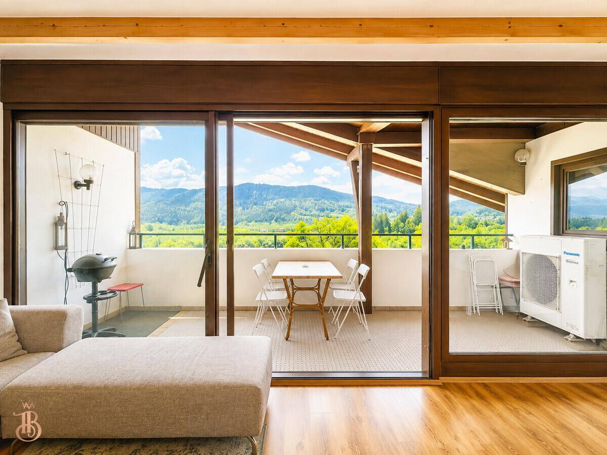 Wohnzimmer mit Schiebetüren zum Balkon, der einen Grill und eine Klimaanlage im Freien zeigt.