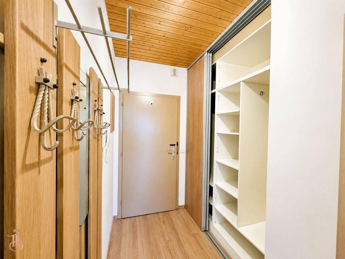 Eingangsbereich mit Holzbalkendecke, Laminatboden, Garderobe und praktischem Einbauschrank.