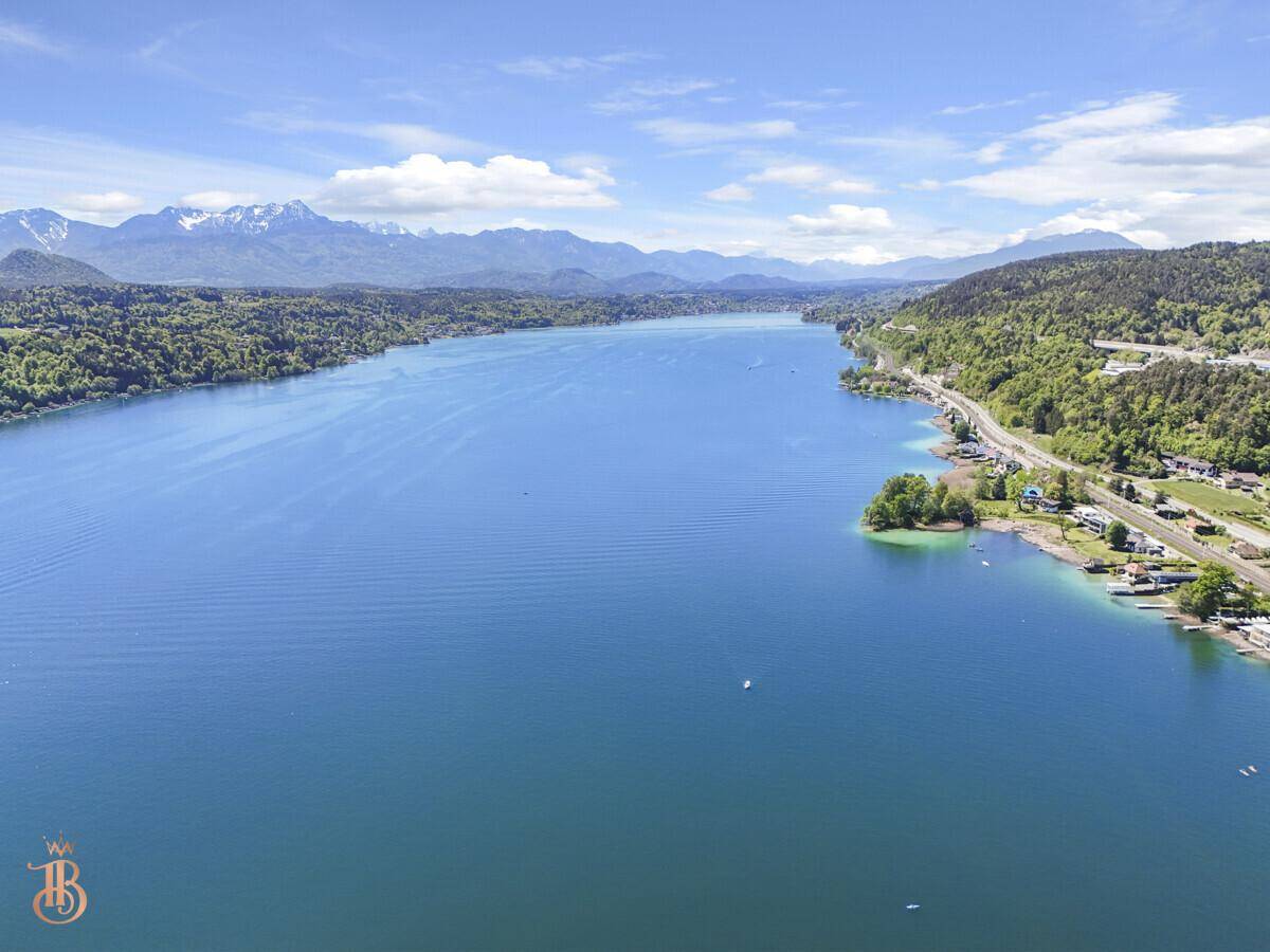 Atemberaubender Blick aus der Vogelperspektive über die weite Fläche des blauen Sees und die Berglandschaft.