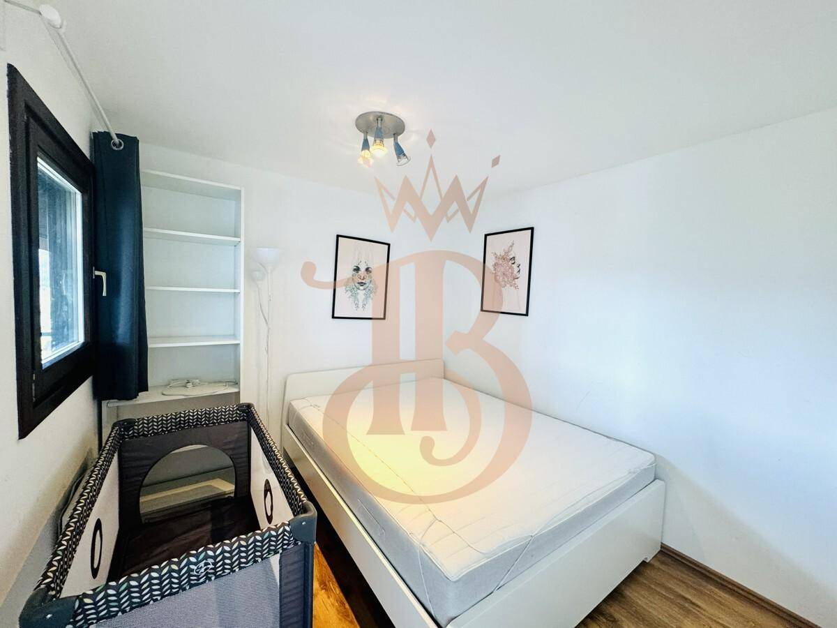 Helles Schlafzimmer mit Einzelbett und Babybett, ideal als Kinder- oder Gästezimmer.