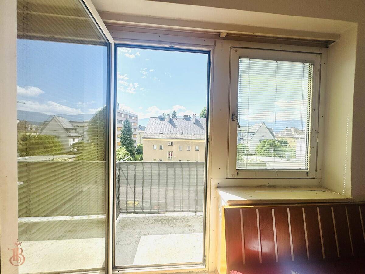Blick vom Balkon auf die umliegende Wohngegend und die Berge im Hintergrund.