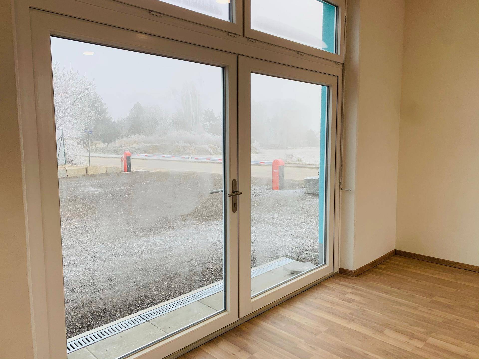 Große Fenstertüren bieten Zugang nach draußen und lassen viel natürliches Licht in den Raum.