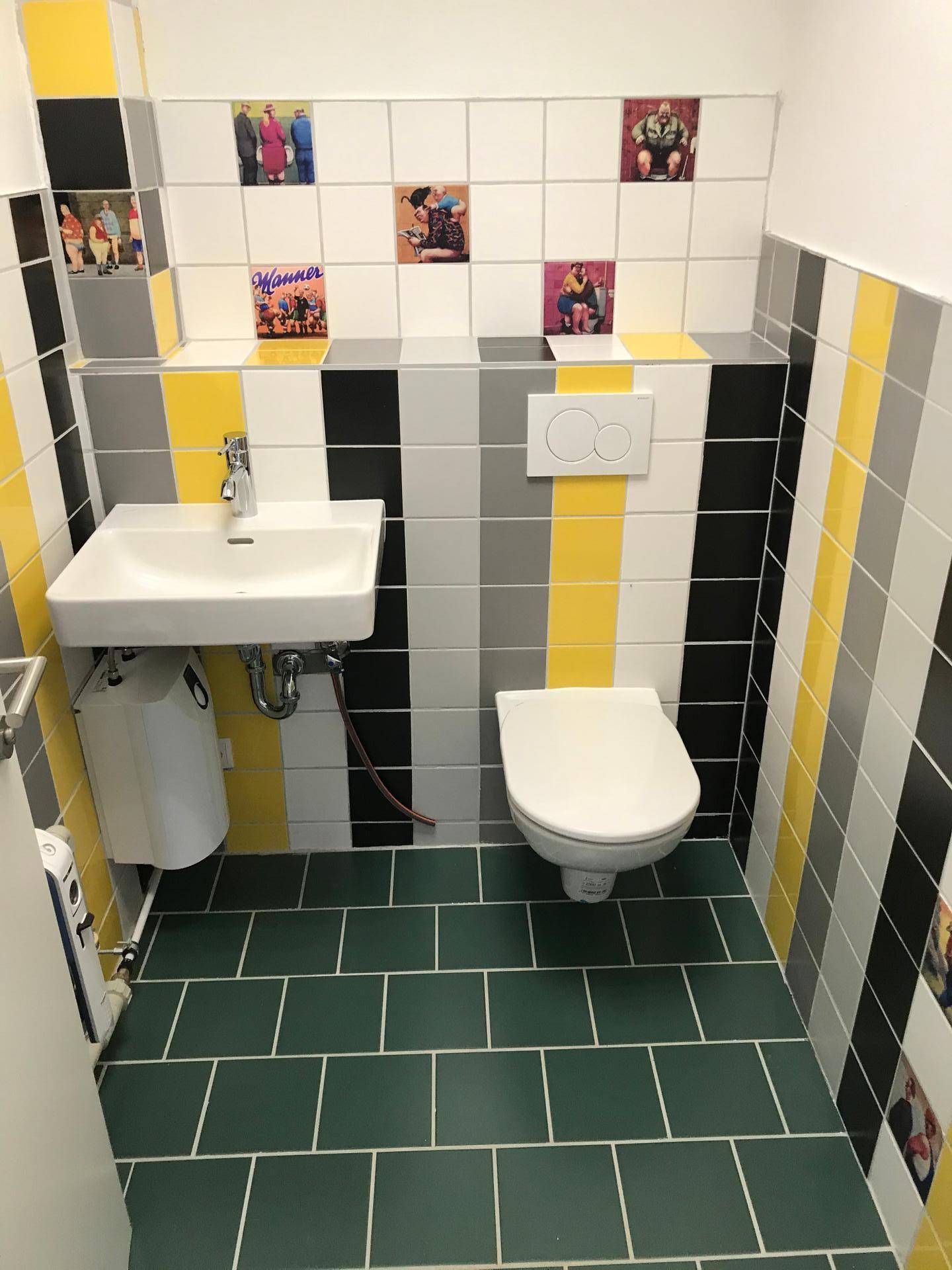 Modernes Gäste-WC mit farbigen Fliesen, Waschbecken und wandhängendem WC.