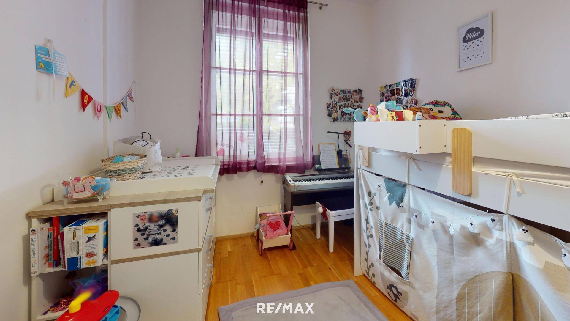 Kinderzimmer mit Wickeltisch, Hochbett und Fenster.
