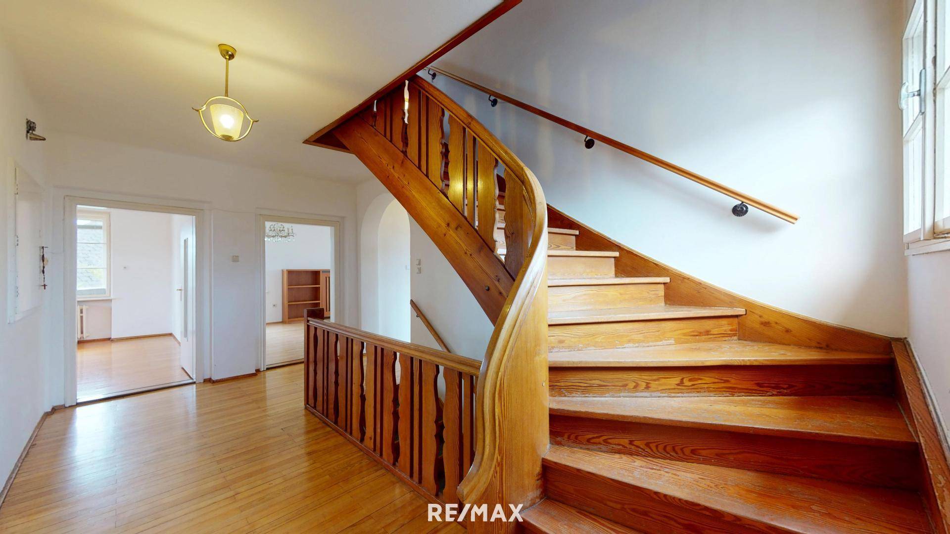 Elegante Holztreppe mit geschwungenem Geländer und Holzboden.