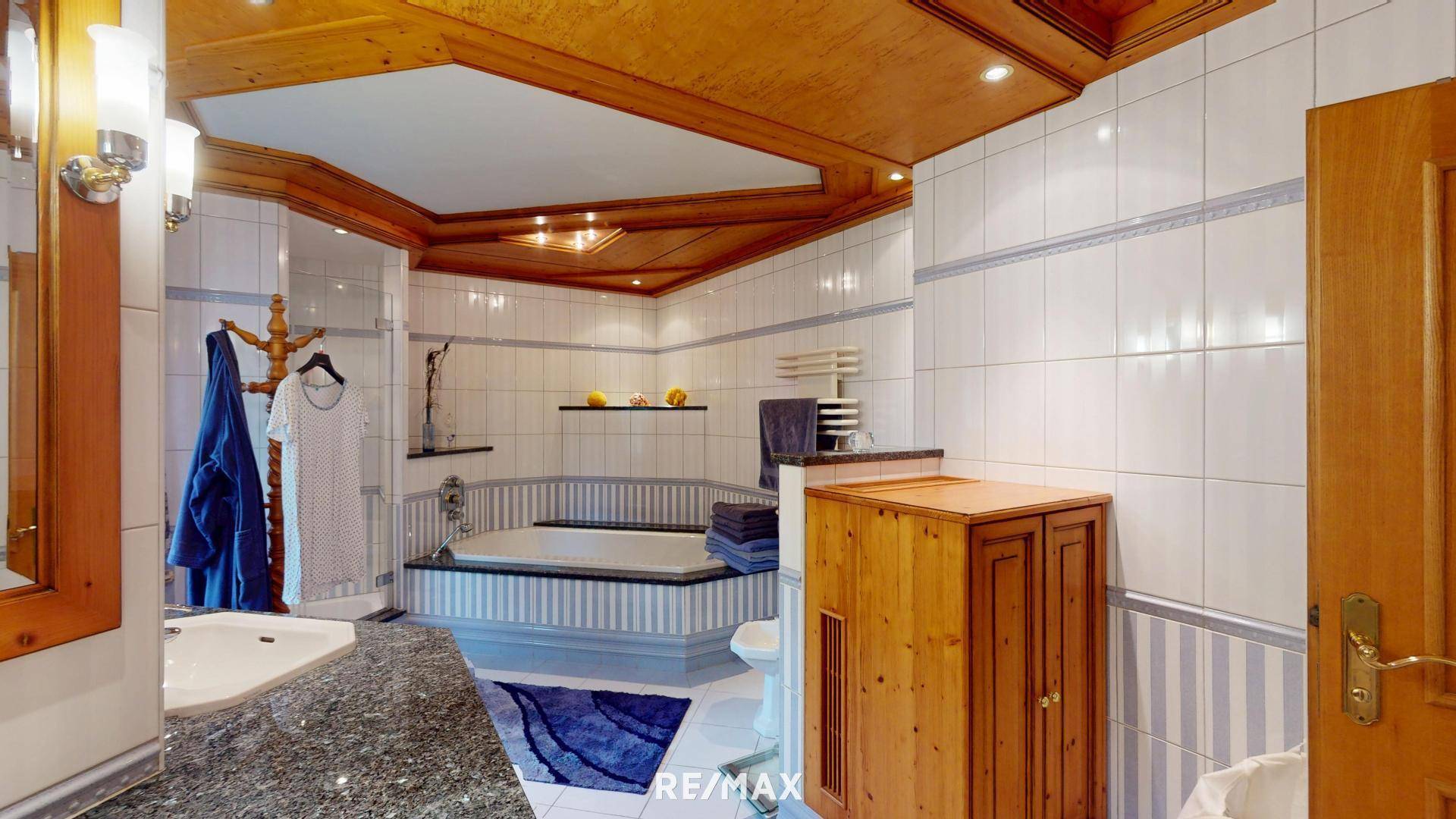 Großes Badezimmer mit Eckbadewanne, separater Dusche und Holzdecke.