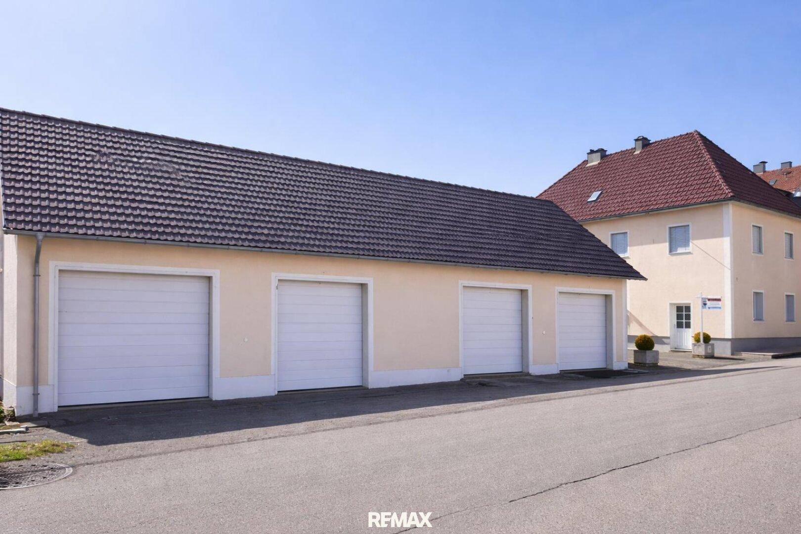 Separate Garagenreihe mit vier Stellplätzen, ideal für mehrere Fahrzeuge.