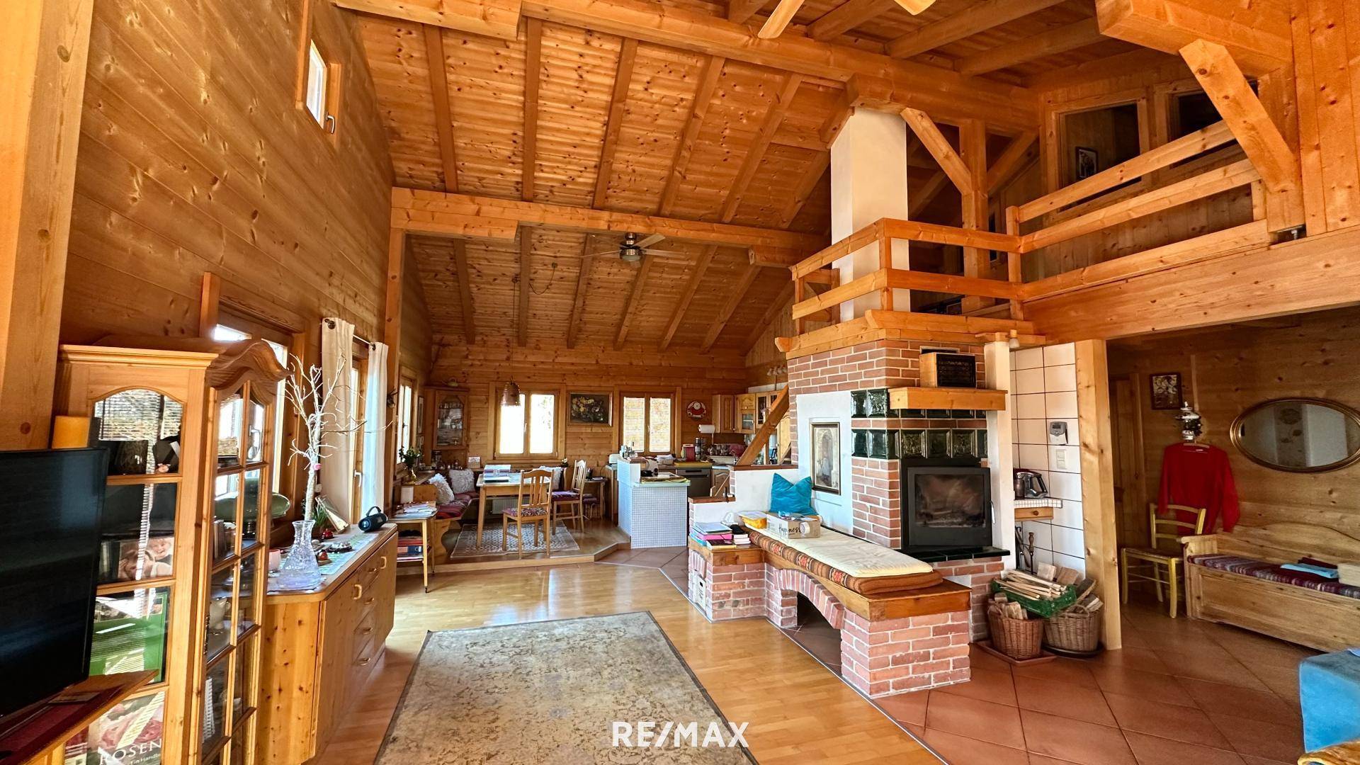 Offener Wohn- und Essbereich mit Holzbalken, Kamin und rustikalem Charme, ideal für gesellige Stunden.
