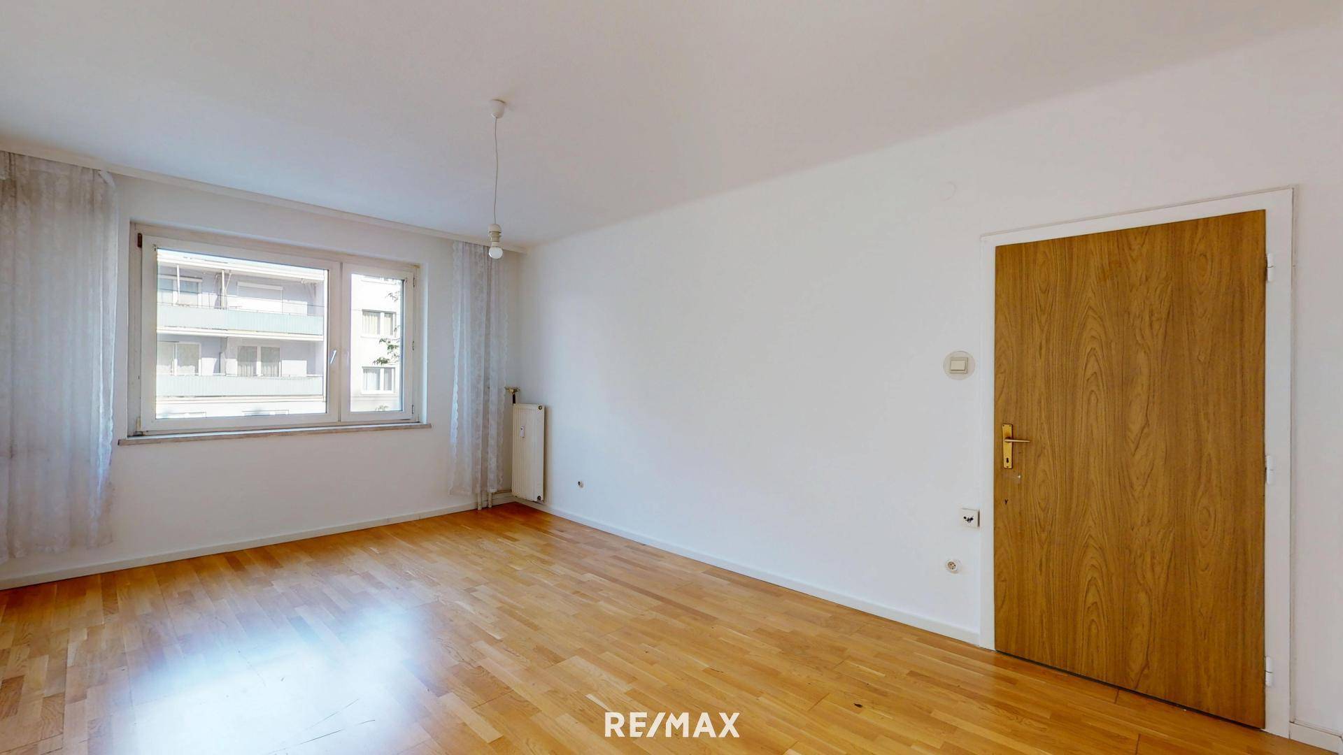 Heller Raum mit Holzfußboden und großem Fenster, bietet viel Tageslicht.