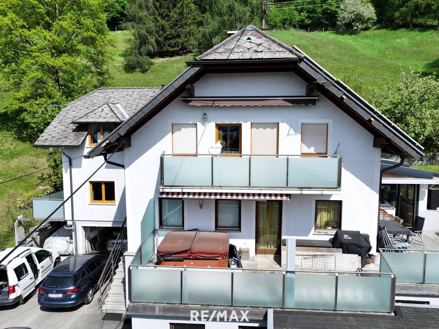 Vorderansicht eines weißen Hauses mit mehreren Balkonen, Terrassen und einem Whirlpool.