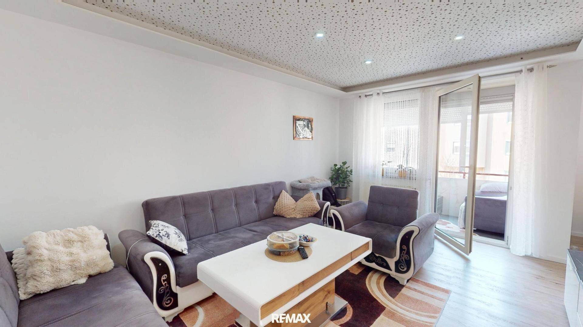 Helles Wohnzimmer mit bequemen Sitzmöbeln und direktem Zugang zum Balkon.