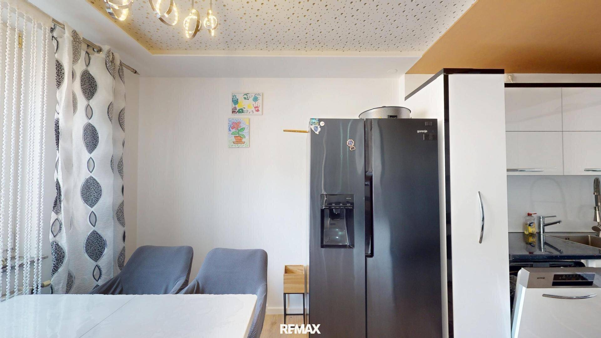 Offener Essbereich mit Kühlschrank und Blick auf die angrenzende Küche.