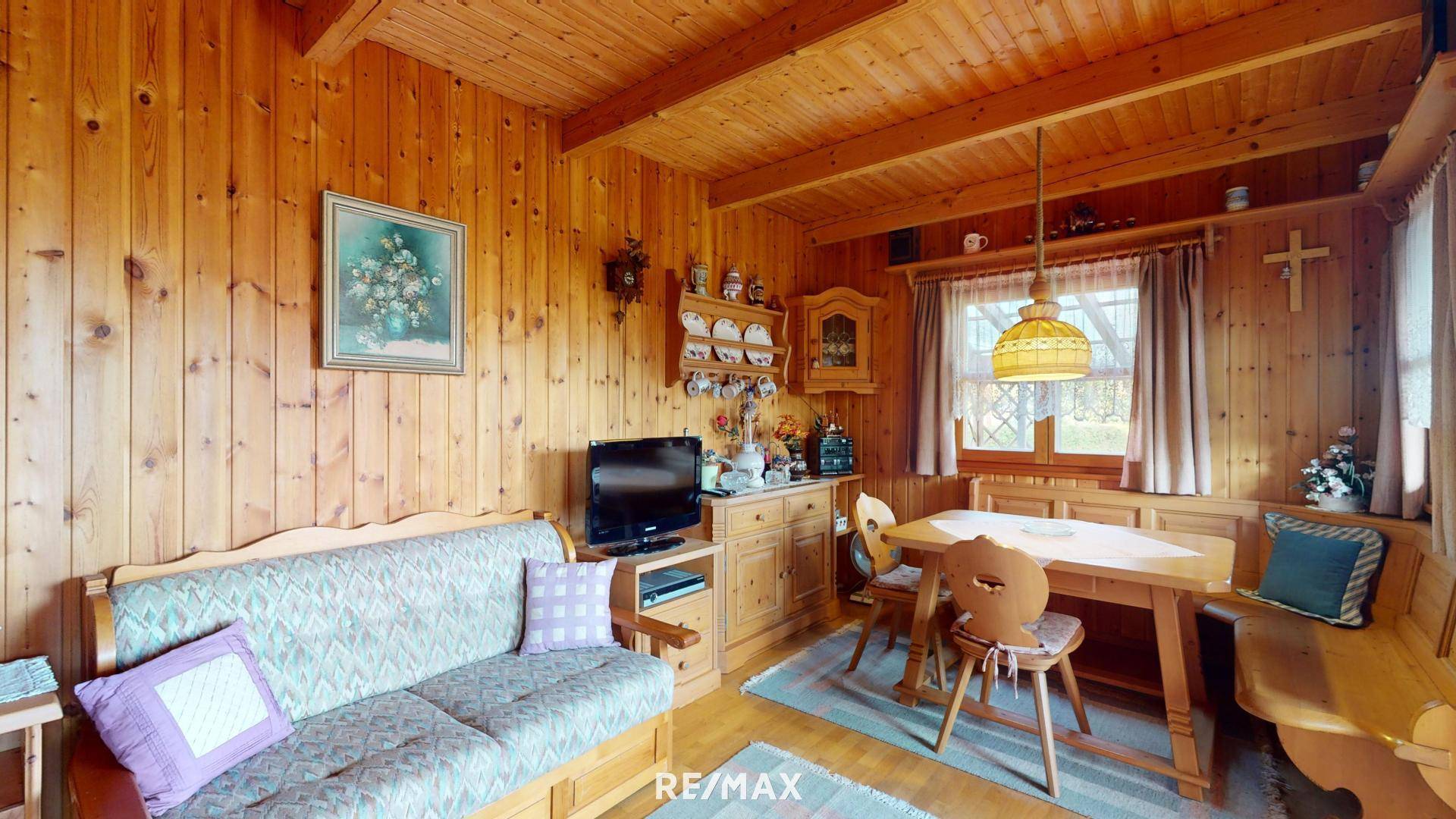 Gemütlicher Wohn-Essbereich im alpinen Stil mit viel Holzvertäfelung und traditionellen Möbeln.