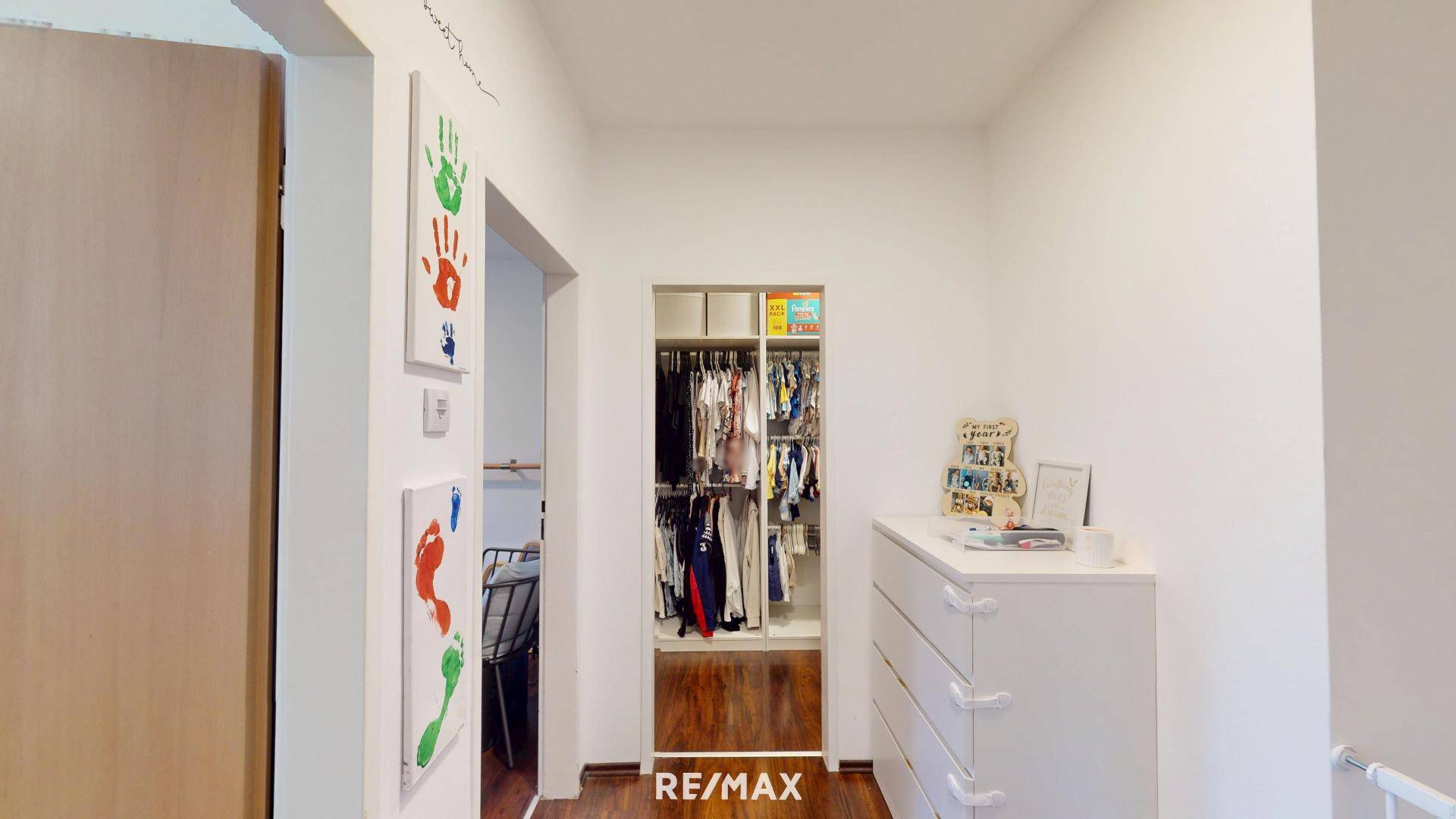 Flur oder Ankleidebereich mit offenem Kleiderschrank und Kommode für Kleidung.
