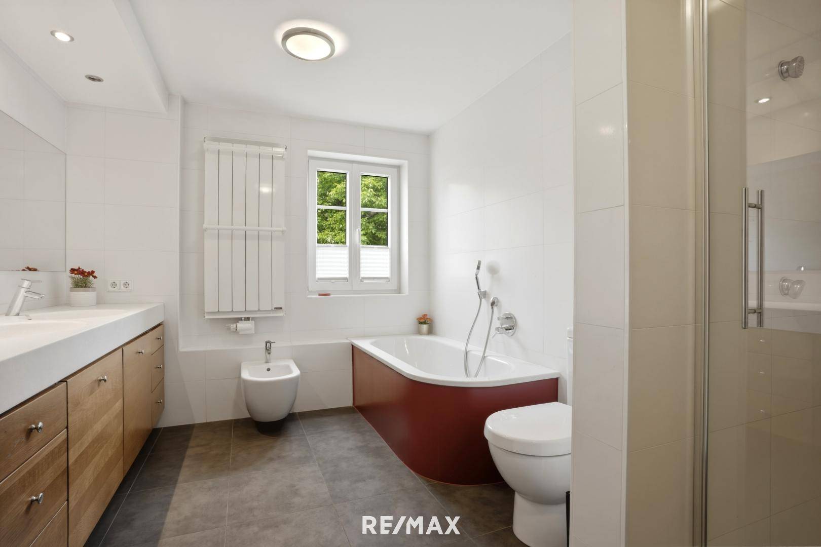Modernes Badezimmer mit Badewanne, Dusche, Bidet und Doppelwaschbecken.