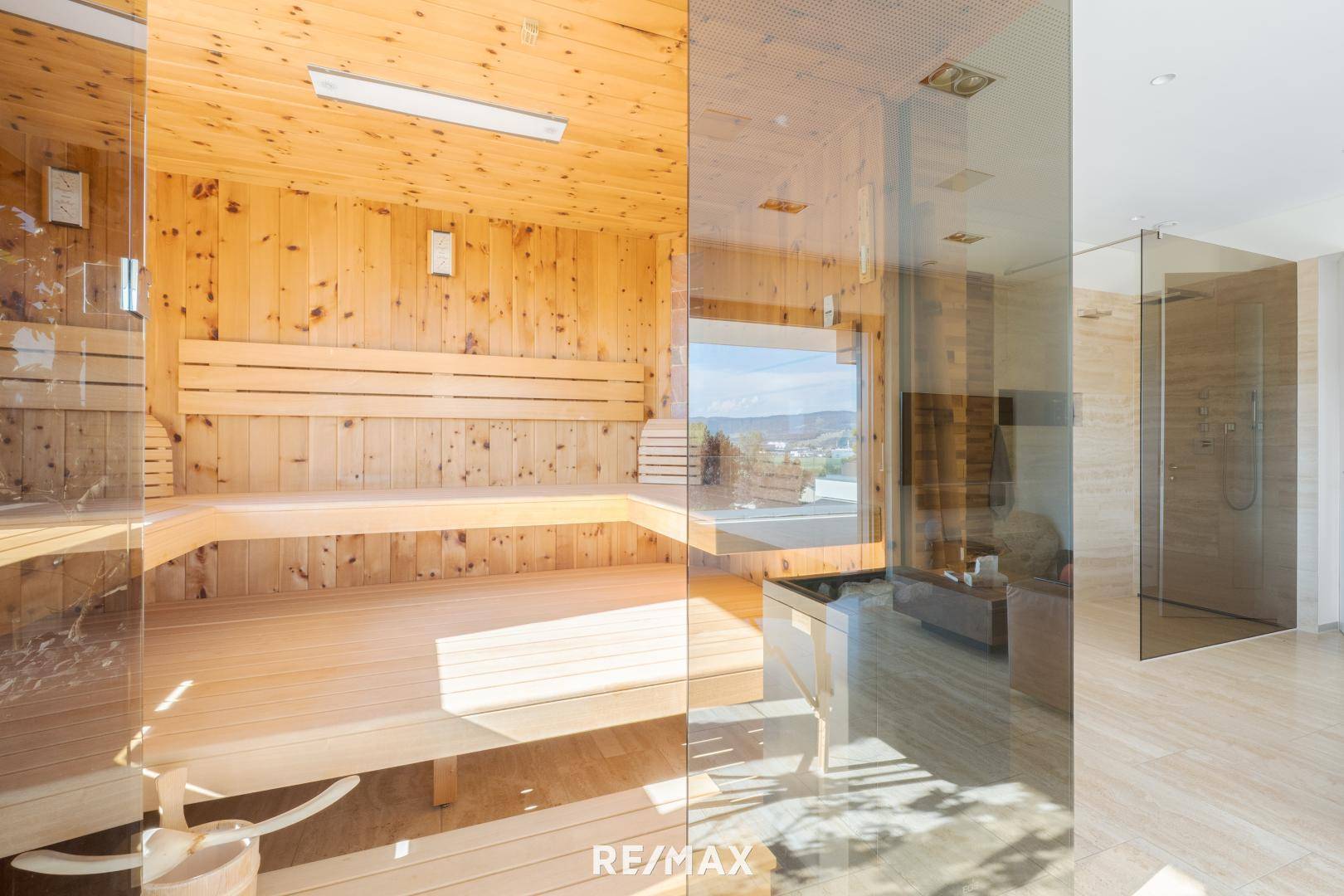 Luxuriöser Wellnessbereich mit holzverkleideter Sauna und angrenzender moderner Dusche.