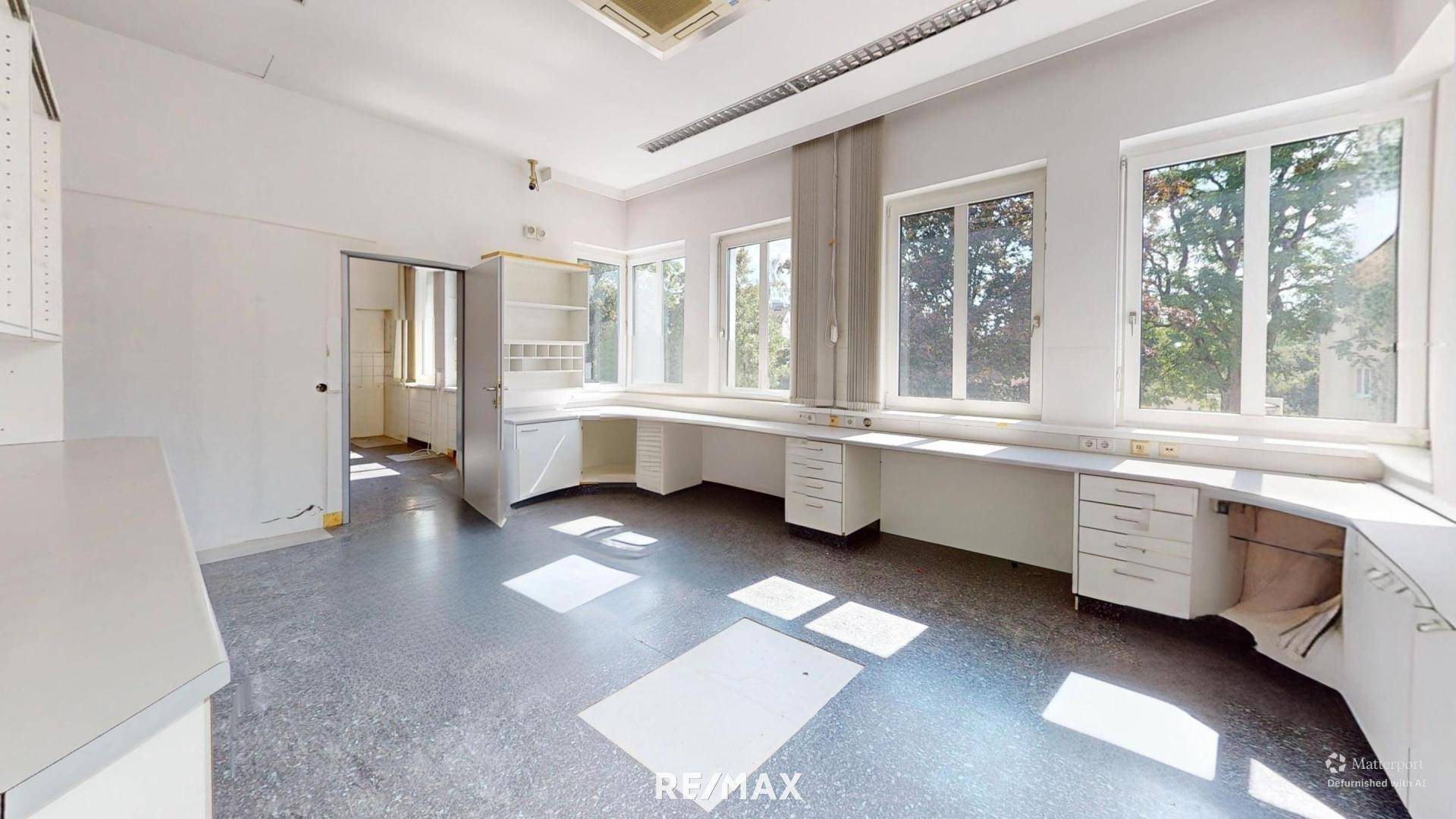 Helles Büro mit mehreren Fenstern, integrierten Schreibtischen und Stauraum, ideal für Arbeitsplätze.