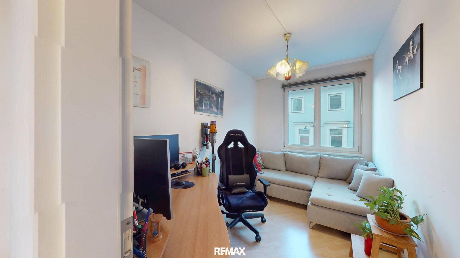 Funktionales Arbeitszimmer mit Schreibtisch, Gaming-Stuhl und Sofa, ideal für Home-Office oder Freizeit.