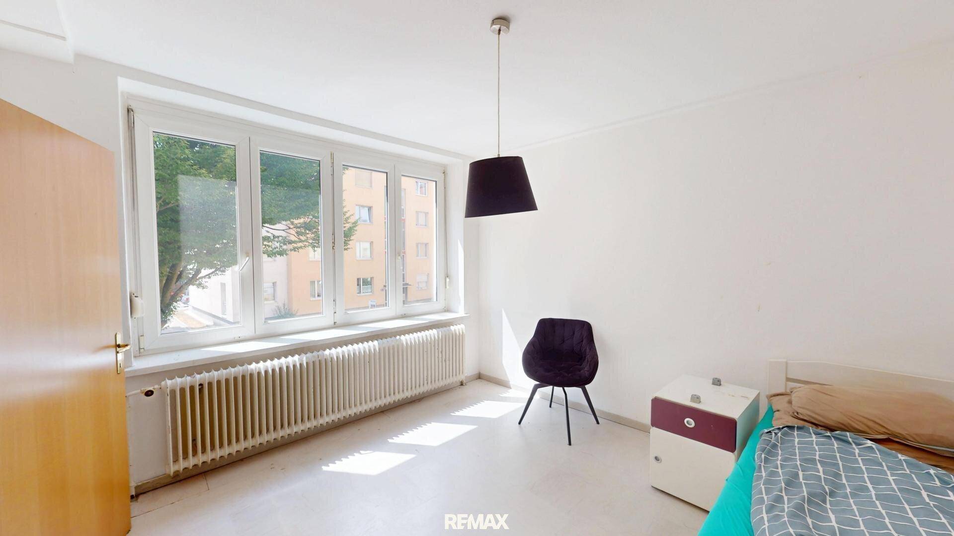 Schlafzimmer mit großem Fenster, das den Raum hell und freundlich erscheinen lässt.