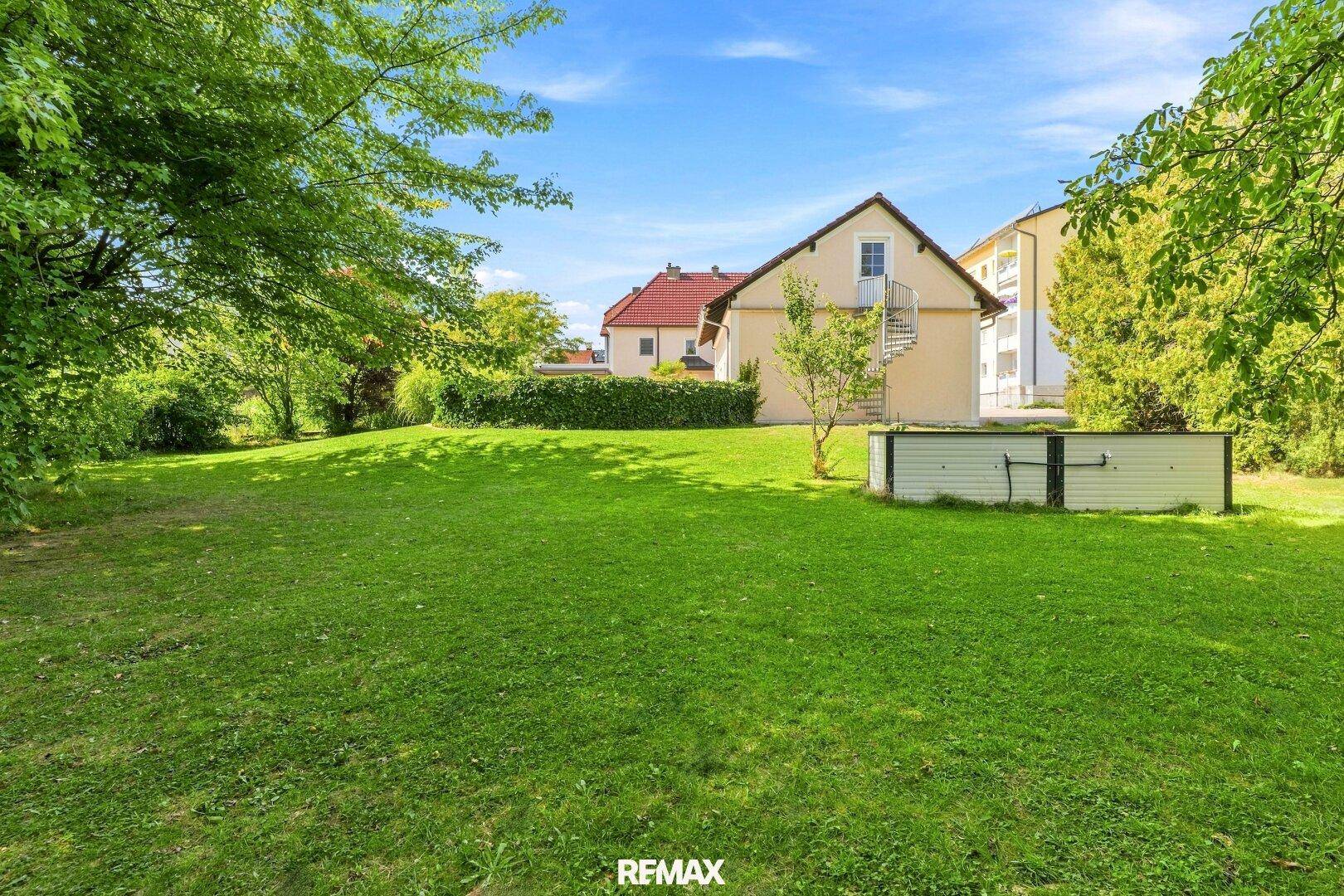 Weitläufiger, gepflegter Garten mit großer Rasenfläche, altem Baumbestand und Blick ins Grüne.