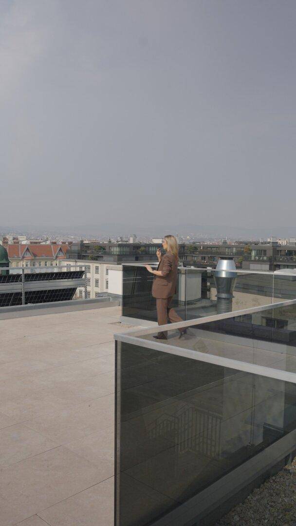 Weitläufige Dachterrasse mit Panoramablick über die Stadt und umliegende Gebäude.