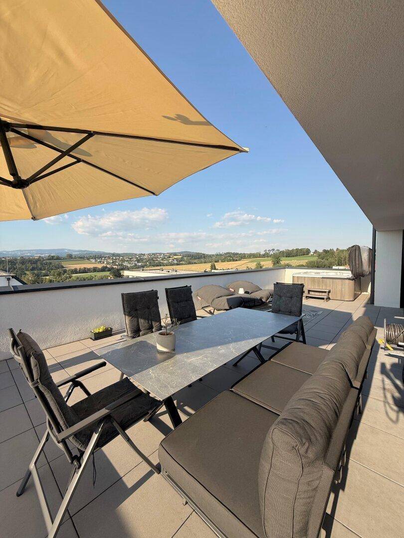 Geräumige Sonnenterrasse mit Essbereich, Lounge-Möbeln, Whirlpool und Panoramablick.