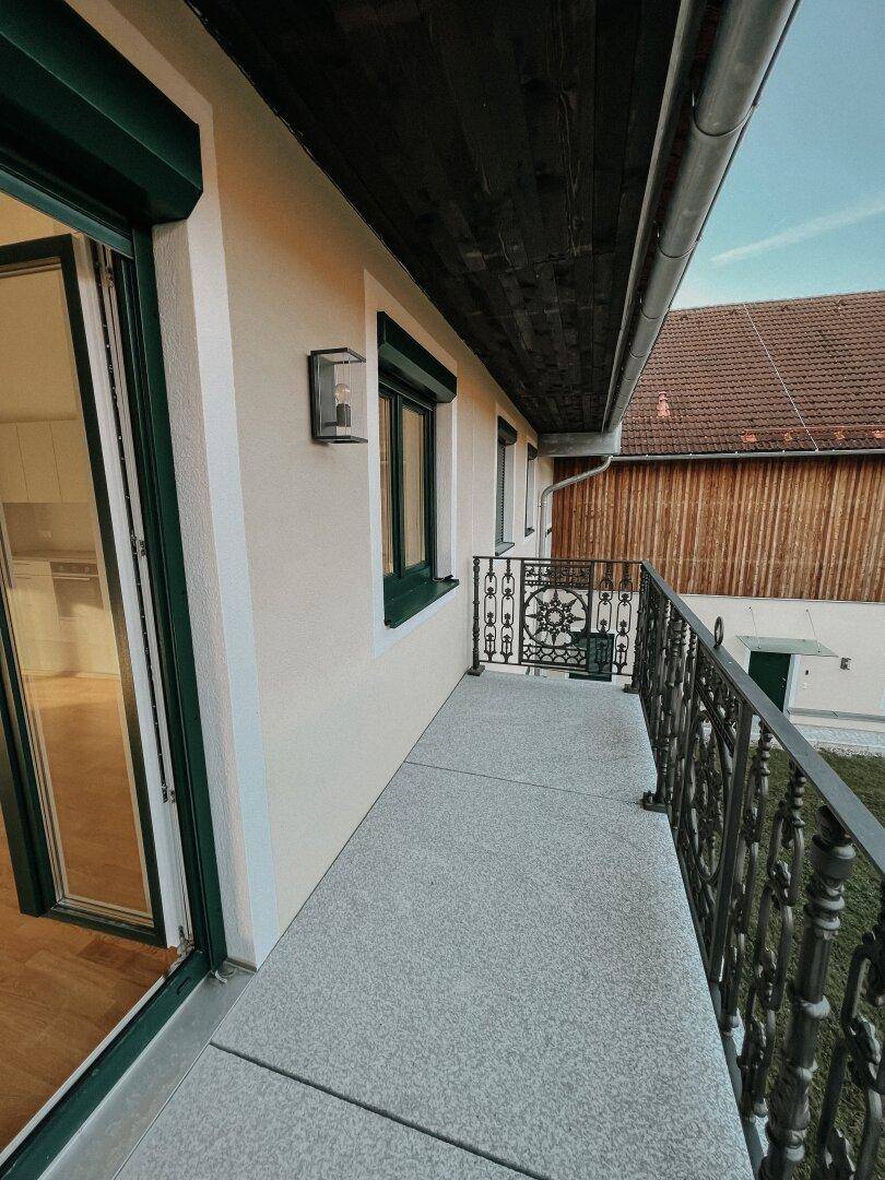 Schmaler Balkon mit schmiedeeisernem Geländer und Blick auf die Umgebung.