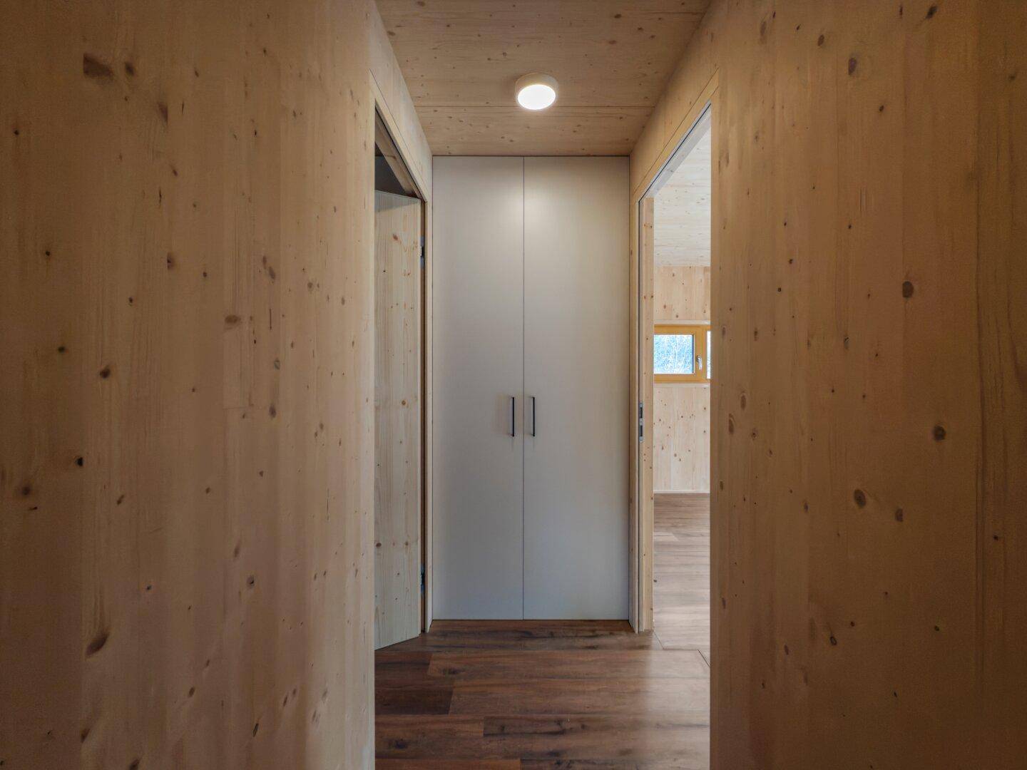 Heller Flur mit Holzverkleidung und integriertem Wandschrank für zusätzlichen Stauraum.