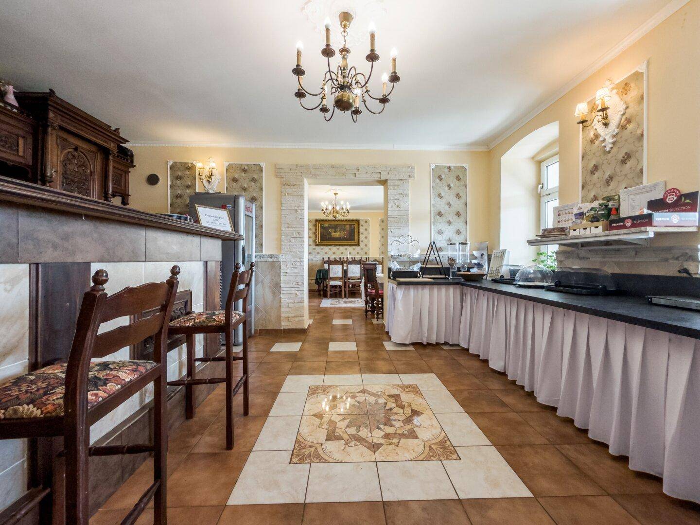 Buffetbereich mit Barhockern und Blick in den angrenzenden, eleganten Speisesaal.