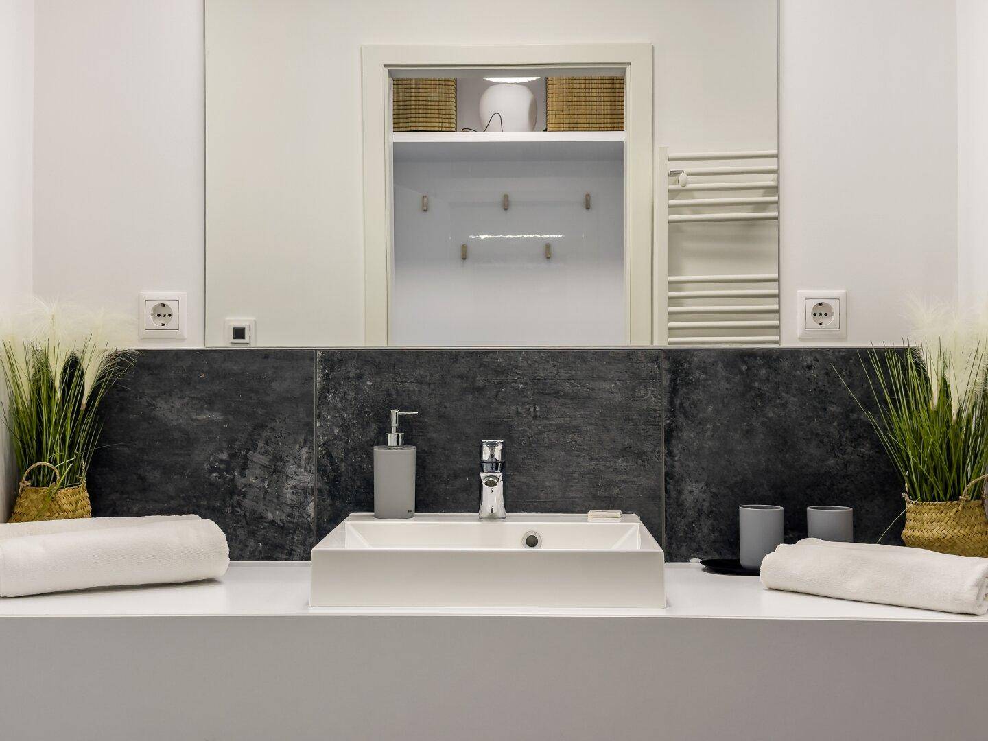Detailansicht des Waschtischs mit modernem Wasserhahn und Dekoration im Badezimmer.