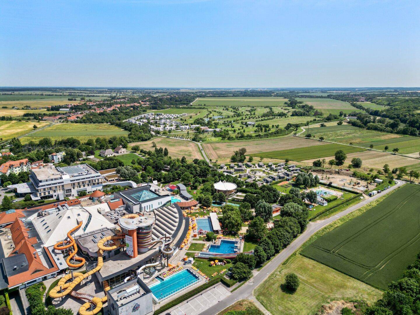 Panoramablick aus der Luft auf die Wohnanlage, den Golfplatz und ein Freizeitresort.