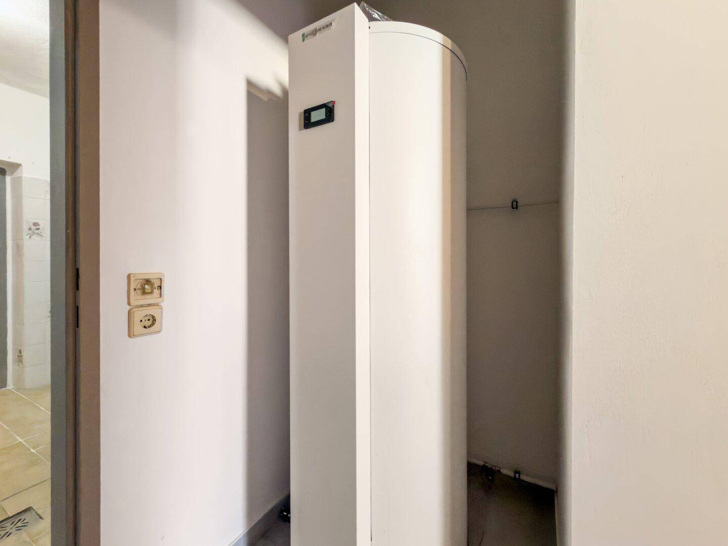 Technikraum mit Warmwasserspeicher und Heizungsanlage.