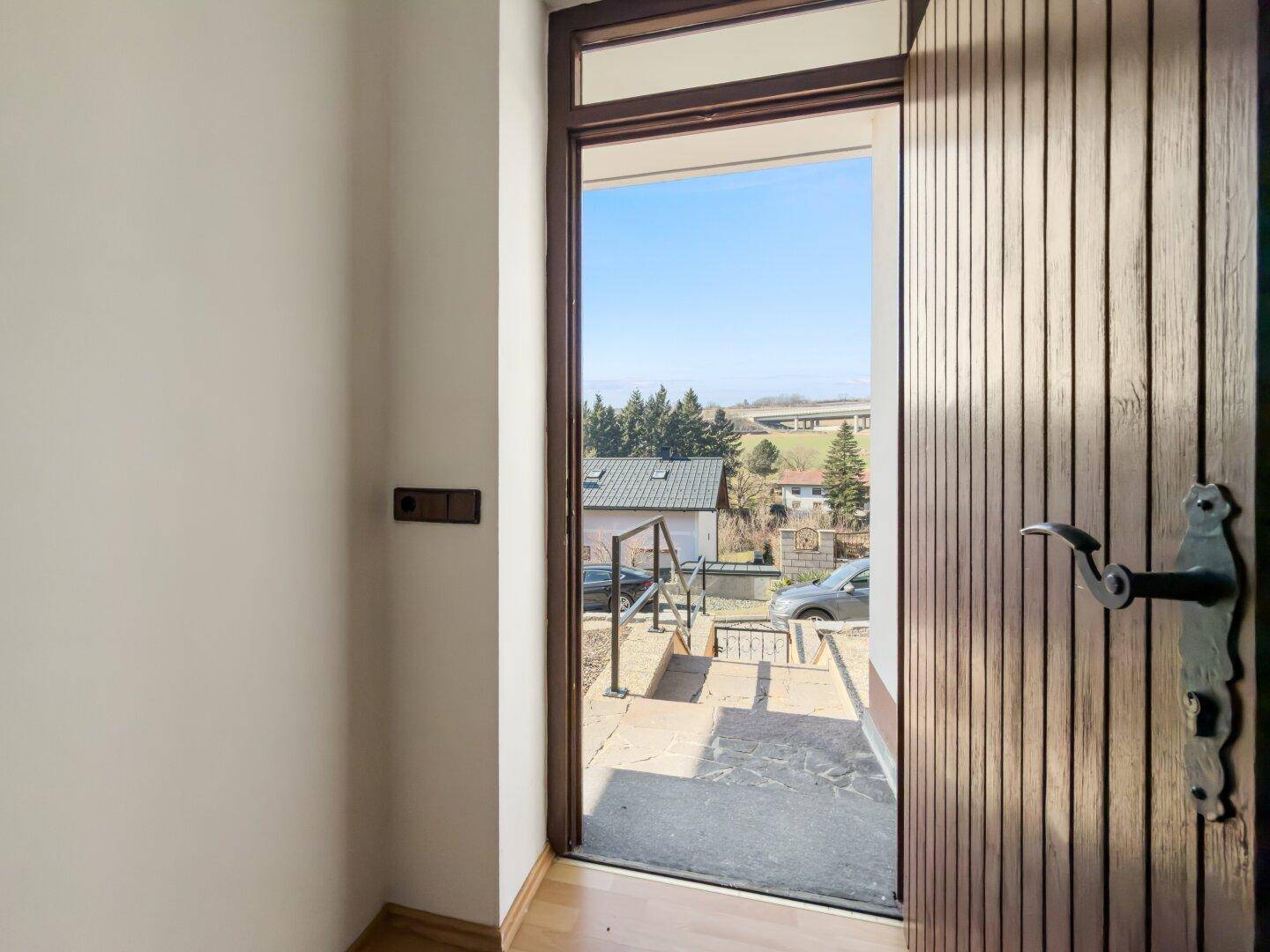 Eingangstür mit Blick auf die Straße und die umliegende Landschaft.