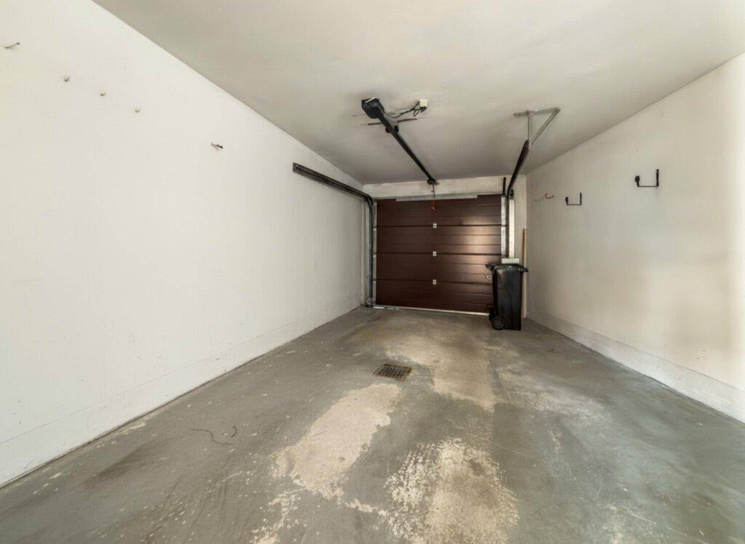 Einzelgarage mit Rolltor und Betonboden, ideal für ein Fahrzeug.