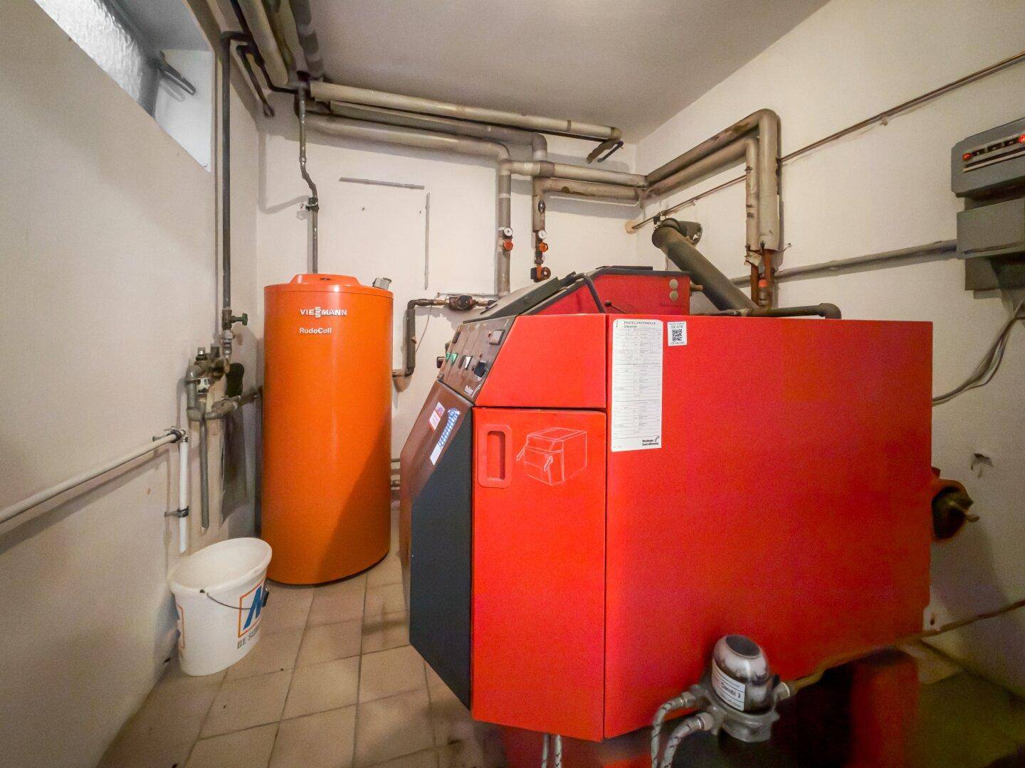 Heizungsraum mit großem Heizkessel und Warmwasserspeicher.