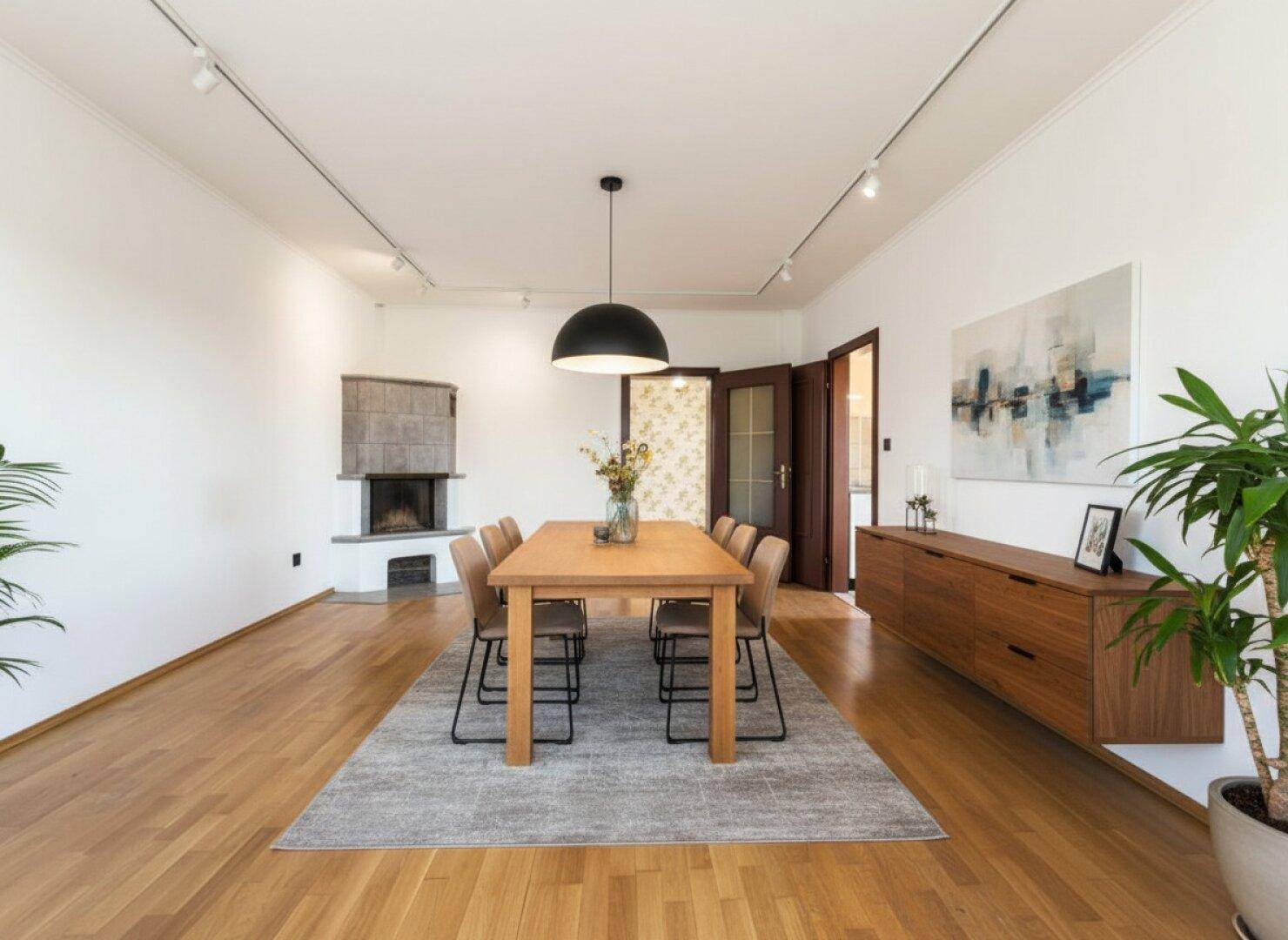 Geräumiger Essbereich mit Holzboden, modernem Esstisch und Kamin.
