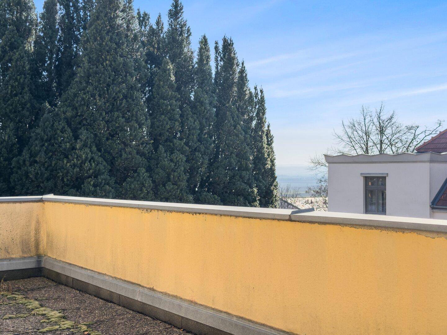 Dachterrasse mit gelber Brüstung und weitem Blick über die Landschaft.