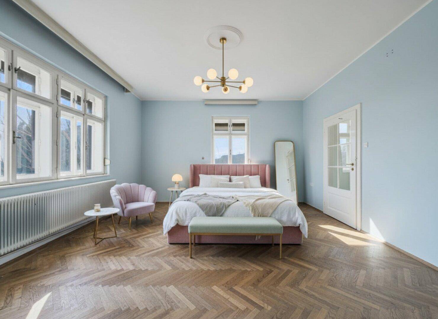 Modernes Schlafzimmer mit Fischgrätparkett, blauen Wänden und rosa Bett, elegant und komfortabel.