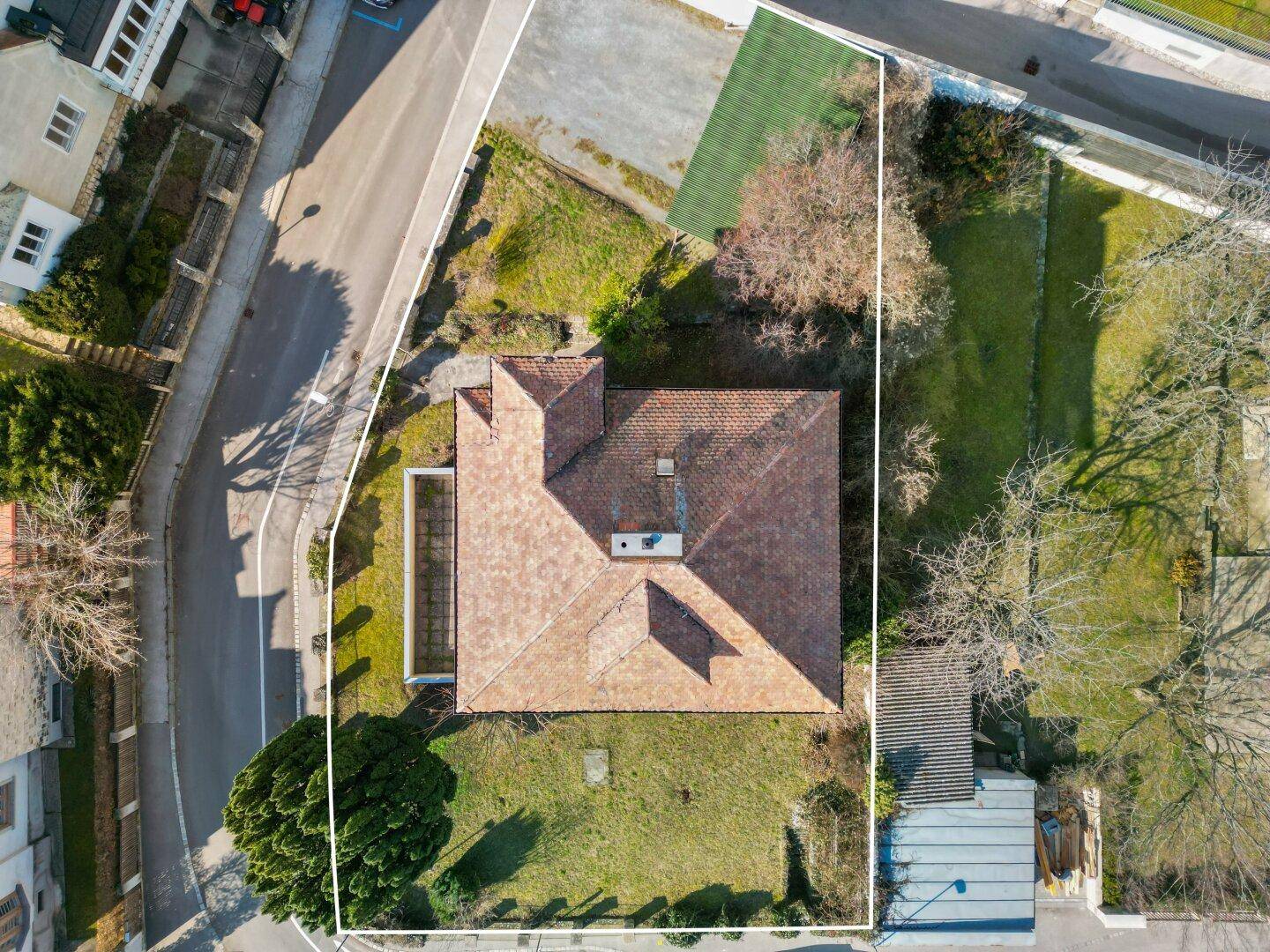 Luftaufnahme eines Hauses mit Garten, umgeben von einer Wohnsiedlung.