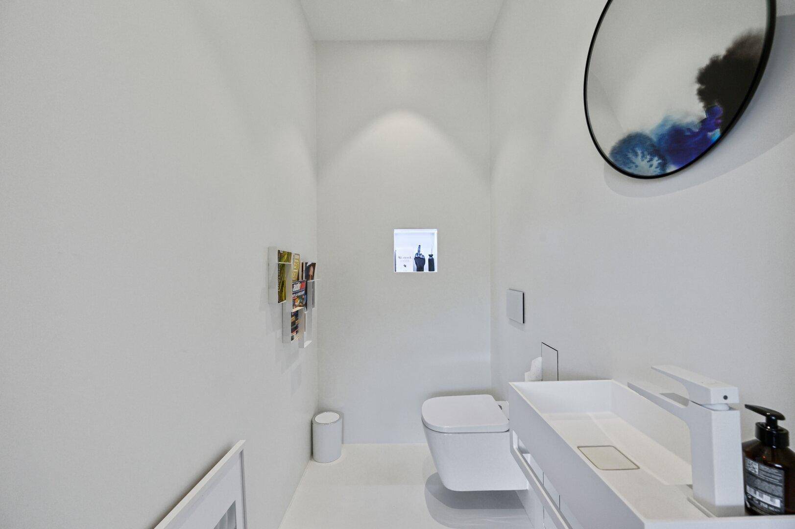 Modernes, minimalistisches Gäste-WC mit weißer Einrichtung und Wand-WC.