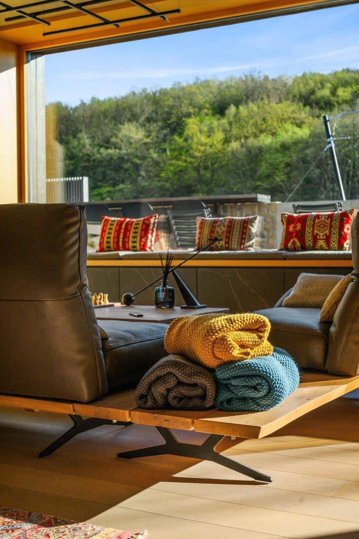 Detailansicht der Liegesessel mit Decken und Blick auf die Terrasse.