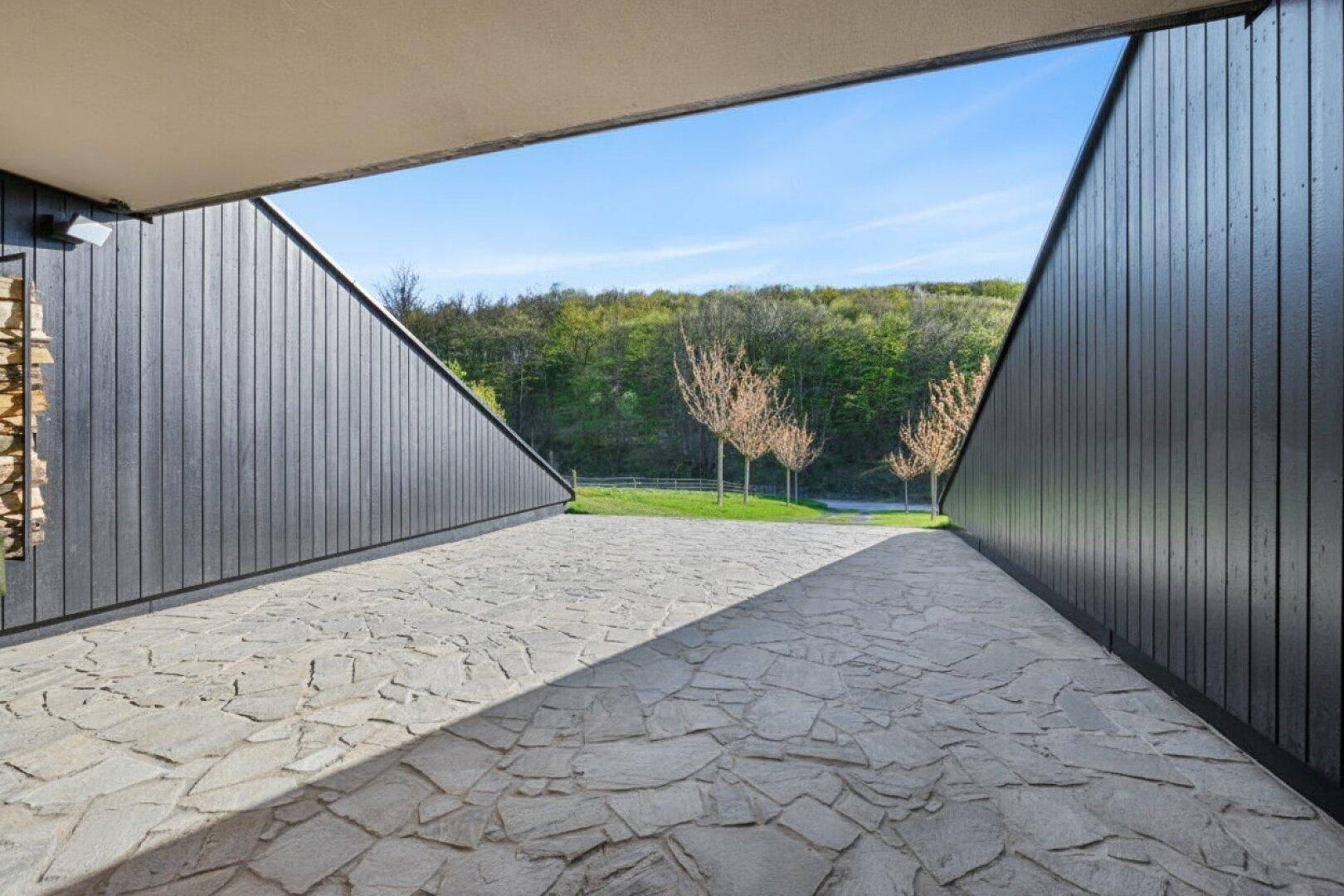 Zufahrt zur Garage mit Natursteinpflaster und moderner Architektur.